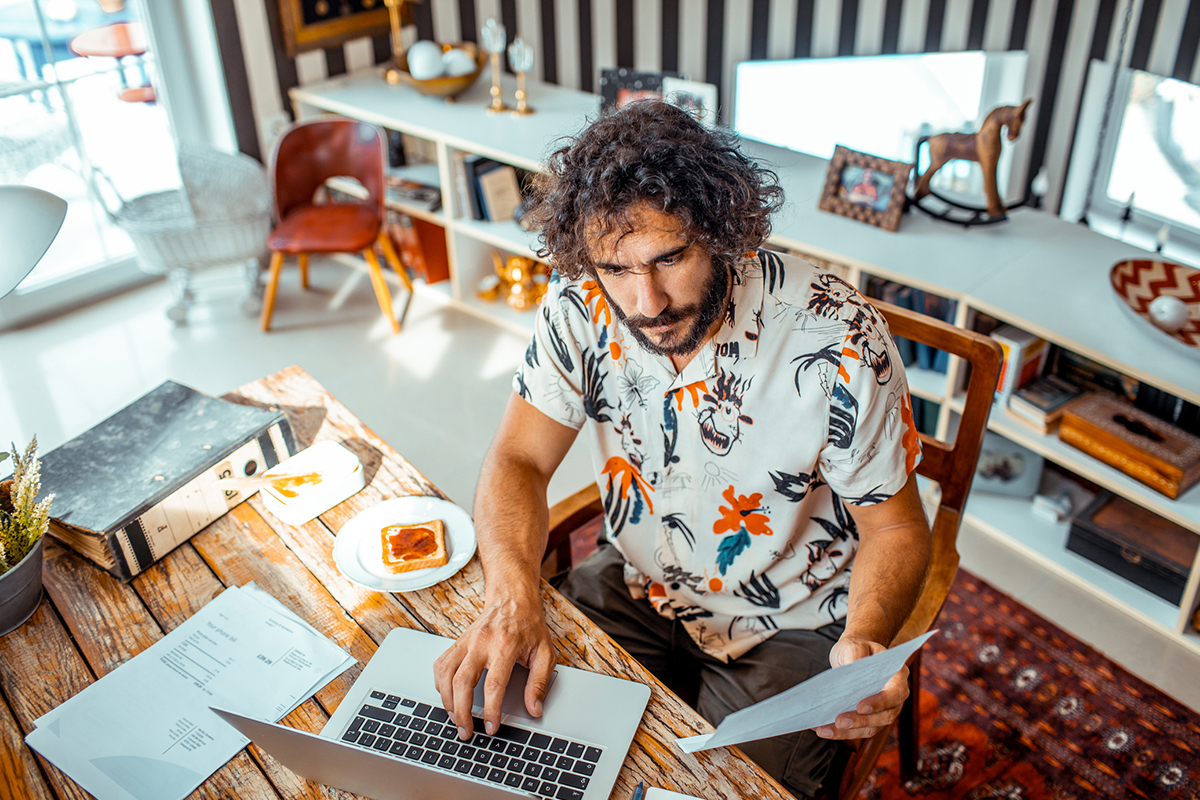 Homem concentrado, comparando e pesquisando dicas de empreendedorismo no computador